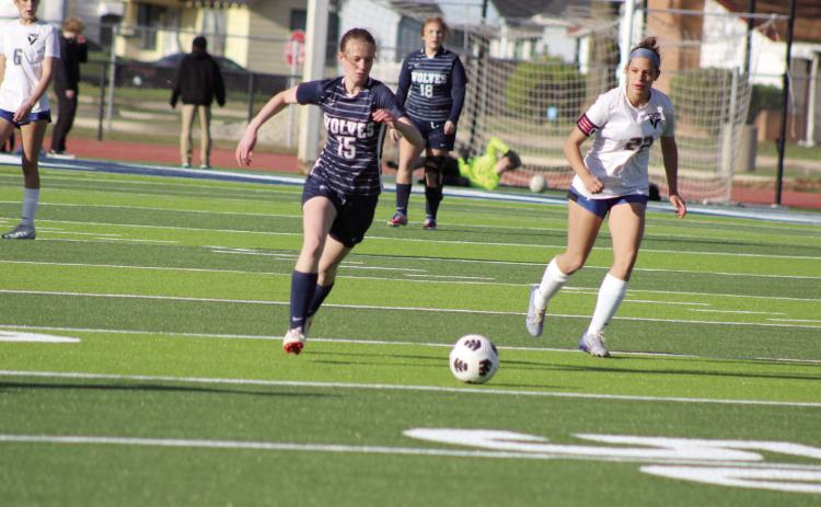 Shawnee’s Kiley Sartin prepares to pass the ball before a Victory Christian player takes possession, as teammate Deanna Pack (#18) looks on during the home game on April 2.