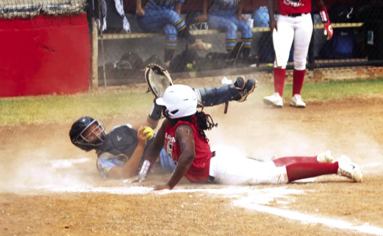 Earlsboro freshman Zory McGregor dives across home plate as the New Lima catcher tries to tag her during the home fast pitch game on Aug. 11. The Lady Wildcats won, 10-0.