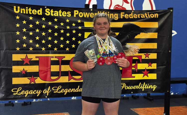 Colleen Williams, 12, of Dale, poses with her prize money and medals after breaking a world powerlifting record of a combined 742 pounds at the United States Powerlifting Federation competition in Denver, CO on Aug. 25. Photo provided.