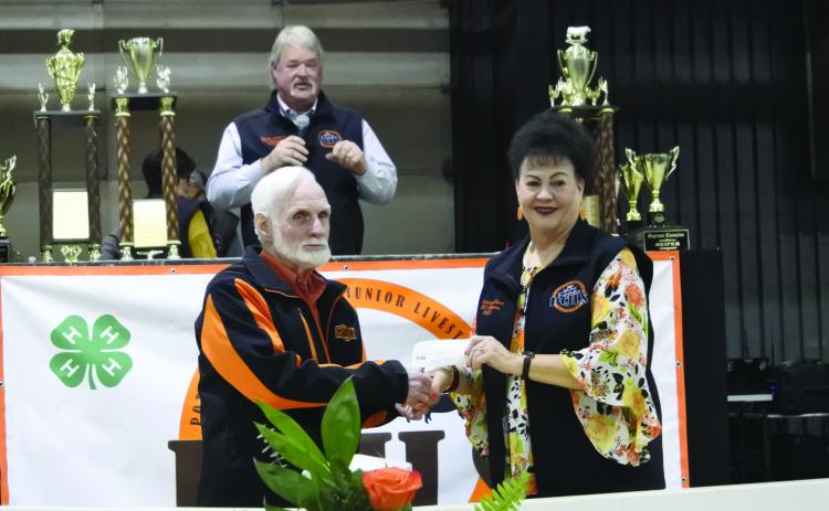 Dr. Joe Taron presents a $10,000 check to Suzanne Gilbert for the PCJLS Scholarship Foundation whie Randy Gilbert talks to the audience about all the ways Taron helps and is involved in the Pottawatomie County Junior Livestock Show. Countywide &amp; Sun/Suzie Campbell