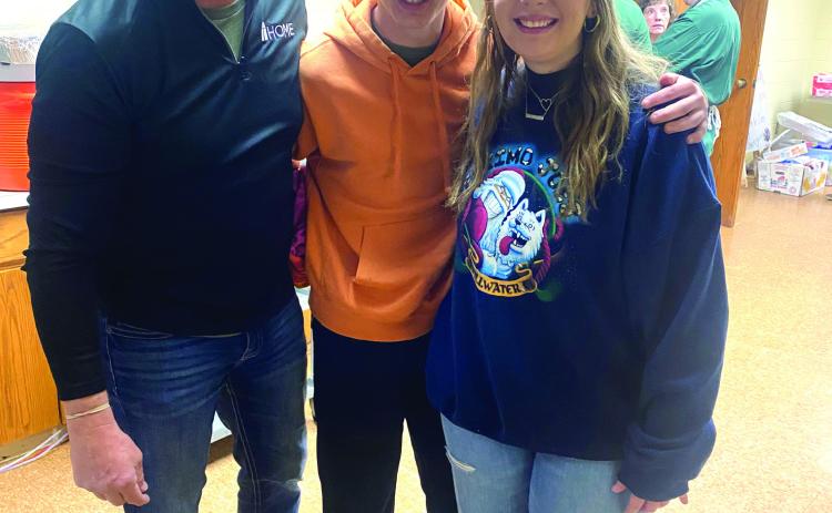 Jerry, Jaxon and Jacey Kuhn (pictured from left) began preparing the Thanksgiving dressing 19 years ago, when the Tecumseh Family Thanksgiving Dinner was started by Suzanne and Randy Gilbert. They have continued this tradition every year since. Photo provided