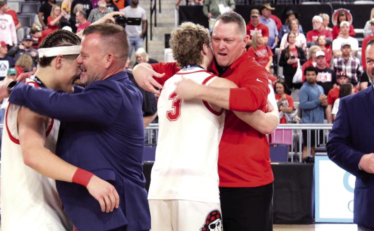 Dale Superintendent Will Jones hugs senior Wyatt Seeley, as Assistant Basketball Coach Josh Forsythe hugs his son, senior Denton Forsythe, after the seniors received their Class 2A State Championship medals, following the Pirates' fifth straight victory at the OG&E Coliseum on March 14. Looking on, far right, is Dale High School Principal Erick Muncy. Photos by Natasha Dunagan, Countywide & Sun