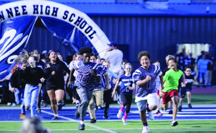Students from Sequoyah Elementary run out of the tunnel before the Wolves football team at the Oct. 23 homecoming game against Tulsa's Edison Prep. Four students from Sequoyah were also honored during the game for perfect attendance.