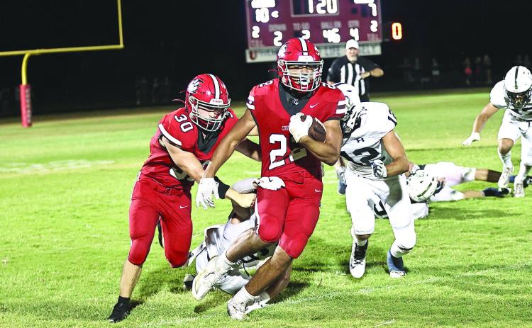Pictured left, North Rock Creek’s Caleb Hawkins escapes two tackles and heads for the winning touchdown. The NRC Cougars opened its season Friday, Aug. 30 with a 17-7 win against Marlow.