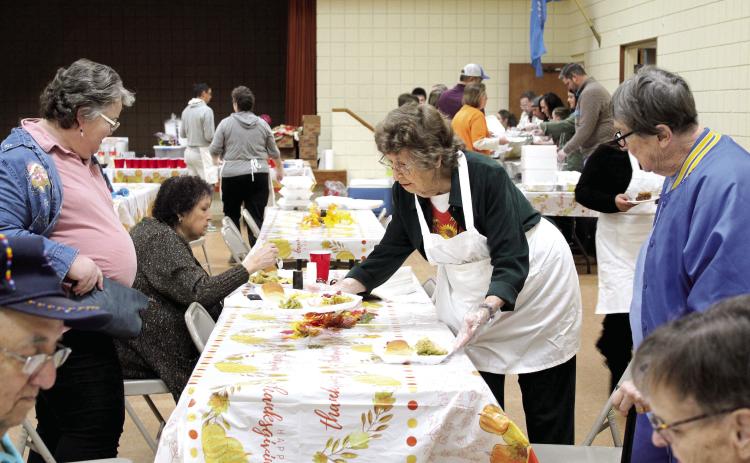 Almeda Dyer, age 91, serves Jean Cutting, left, and Claudia Rice during the 17th Annual Tecumseh Family Thanksgiving Dinner, held at the Tecumseh City Hall Auditorium on Nov. 24. Dyer said she usually volunteers at the Golden Age Senior Center and plans to walk in the upcoming Grinchmas parade. Also shown is Dr. Carol Crouch, second from left, who is a tribal liaison with two groups who have sponsored the meal for nine years. Countywide &amp; Sun/Natasha Dunagan