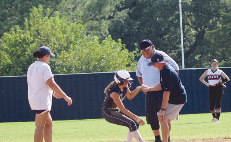 Asher sophomore Cadence Leba is helped up by Assistant Coach Scott Dubler, after stealing second base and hurting her foot while sliding. She went on to steal third and home.