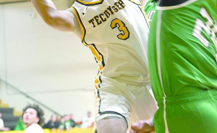 Tecumseh senior Jekhi Owens puts up a basket despite being double-teamed during the Jan. 13 home game against Jones. The Savages won 70-62. Earlier that night, the Lady Savages lost 35-63. Photo courtesy of Kenetta Lisenbee