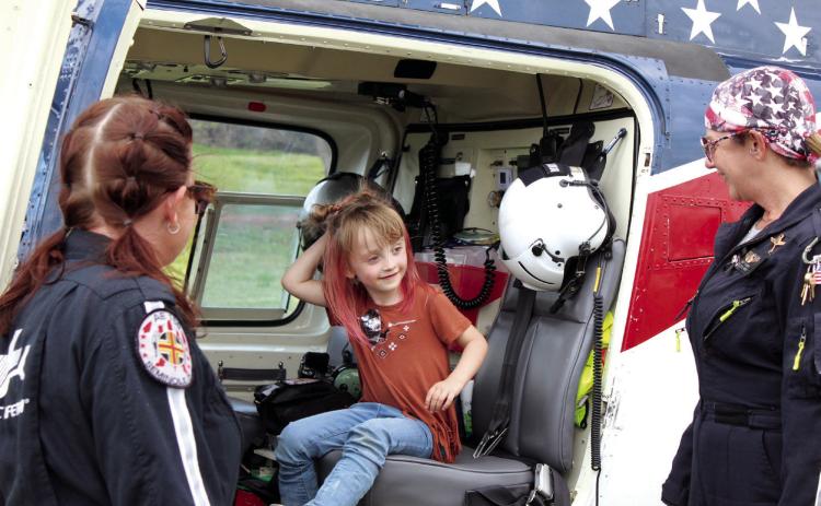 Savanna Garlington, 4, of Maud, talks with paramedic Britney Little, left, and nurse Amy Caudill, far right, while sitting in the Air Evac helicopter, out of Seminole, during the Touch A Truck and Beyond event, April 6, at the CPN Festival Grounds. In this third annual event organized by the Pottawatomie County Emergency Management,  there were 72 agencies and community partners in attendance, including fire departments, law enforcement agencies, large equipment operators, two helicopters and others.