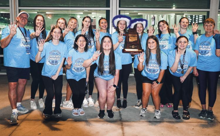 The Shawnee High School Girls Swim Team and their coaches Bob McNeil, far left, and Valarie Colburn, far right, pose with their trophy after winning the OSSAA Class 5A Girls Swimming State Championship at Jenks High School on Feb. 25. This is their fourth state win in a row. Photo provided by Coach Valarie Colburn
