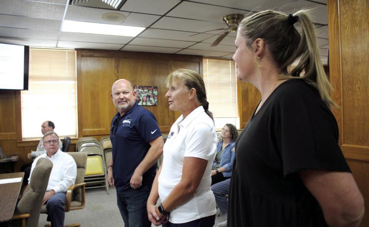 Shawnee Head Swim Coach Valarie Colburn speaks, as Athletic Director Dax Leone, left, and Assistant Athletic Director Julia Holland listen at the Oct. 2 Board of Education meeting. Colburn was named the 2022-23 OSSAA Swim Coach of the Year. Countywide &amp; Sun/Natasha Dunagan