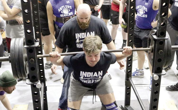 Asher Head Powerlifting Coach Bobby Carnes spots for senior Brogan Culwell as he does squat lifts. Culwell is the first person at Asher to join the “1,000-Pound Club.” Photo provided.