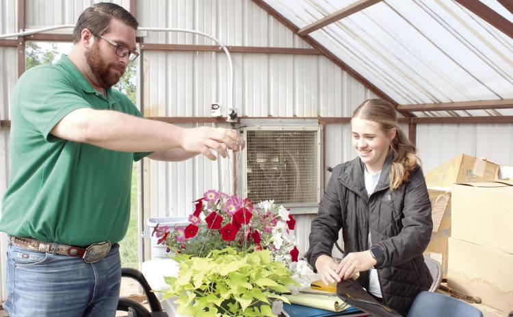 Corey Wilson, of the Pottawatomie County Farm Bureau, leaves with two hanging baskets after checking out with FFA student Maddilyn Taron at the annual Tecumseh FFA Plant Sale on May 2. Natasha Dunagan, Countywide & Sun