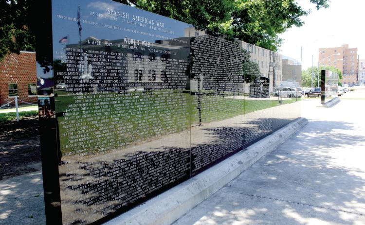 The Pottawatomie County Veterans Educational Museum is reflected in the black granite panels of the Oklahoma Veterans Memorial Wall at the Oklahoma Veterans Memorial in Woodland Veterans Park. Shawnee Veterans Memorial Committee President Bill Ford recently reflected on the history of the memorial park and military museum, and retired Major General Douglas Dollar shared information on the National Society of the Scabbard and Blade opening their headquarters in the museum.