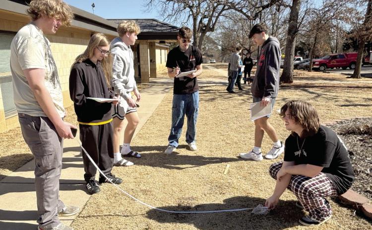 Tecumseh Forensic Criminology students Jackson Lindamood, Gavin Borboa, Jace Musgrave, Wyatt Heck, Tristan Baney, and Jacob Holmes practice taking proper measurements of evidence as part of their outdoor lab. Cheyanna Dietz, THS Intern