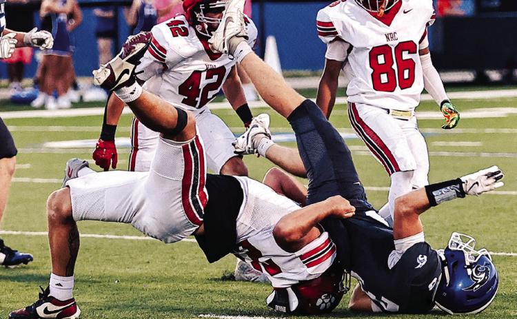 NRC's Brodie Grace stops the Harrah runner in the Sept. 11 game. Photos courtesy of Gowin Photography