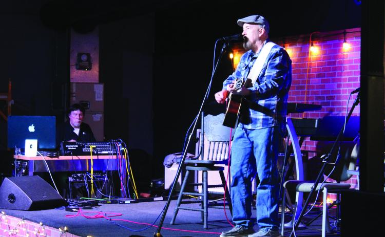 The host for Songwriter Night at Music Unlimited, Kevin Hall, performs one of his songs on Jan. 3, as business owner Jeff Hawkins works the sound and lights. Hall suggested the event to Hawkins in 2022, where singer-songwriters are invited to try out their songs on an audience. They host about eight artists on the first Friday of each month since it resumed in Oct. 2024. Countywide & Sun/Natasha Dunagan