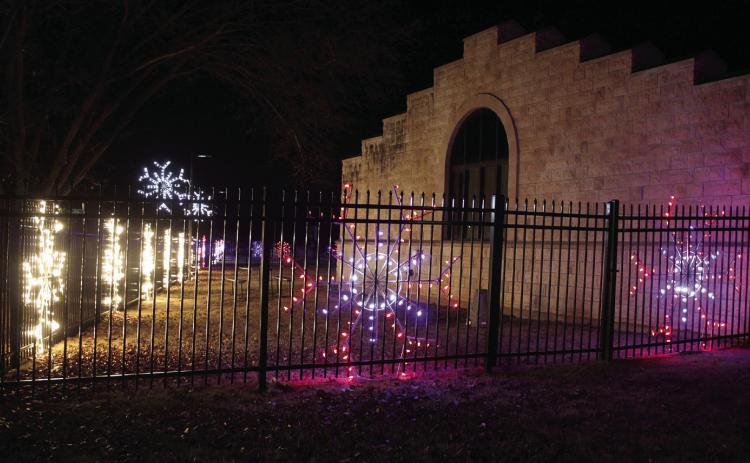 Lighted snowflakes of different colors have been refurbished by the Pottawatomie County Historical Society and are on display on the western and southern sides of the Paul and Ann Milburn Center in Shawnee. Museum Director Ken Landry said they were given 50 snowflakes from the City of Shawnee last year, and they have all but four restored. Of those, 36 are on display at the museum, and they loaned 10 to SEFF for their Santa float.