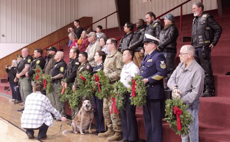 A line of veterans, Sheriff's deputies and a Gold Star father, David Hendrickson, far right, prepare to place wreaths in honor of those lost in each military branch, POW-MIAs, and Gold Star Families during the Wreaths Across America Ceremony, held at Macomb High School gymnasium on Dec. 13. Also shown are members of the Rolling Ambassadors motorcycle club who would place wreaths on the graves of veterans at Prairie View and Romulus cemeteries following the event. See full cutline below.