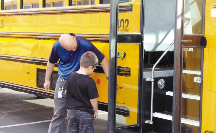 Shawnee Bus Driver Tom Wondrock shows a boy where the charging port of an electric school bus is, during the First United Bank Electric Vehicle Show on Oct. 21. Countywide &amp; Sun/Natasha Dunagan