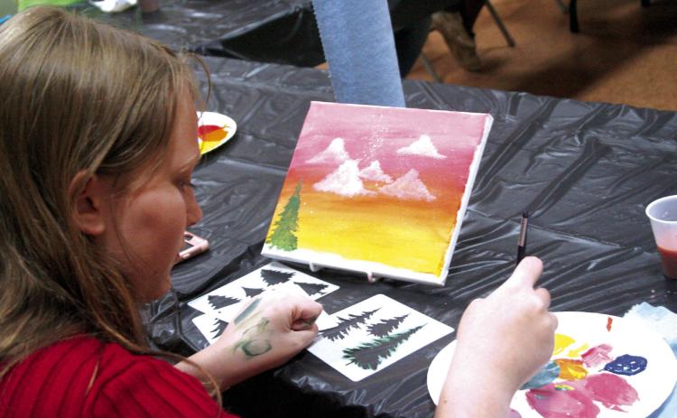 Olivia Hill, summer volunteer at the Tecumseh Public Library, paints a nature landscape at the library’s Summer Learning Event on Wednesday, June 21. Countywide &amp; Sun/Valerie Scott