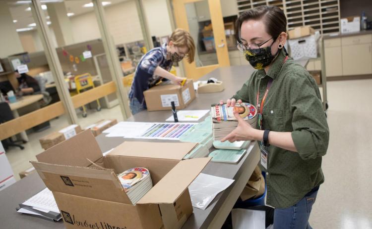 Above, Tribal member Britt Muirhead prepares boxes of books at the Pioneer Library System in Norman, Friday, Sept. 24, 2021. This year Pioneer Library System Foundation is donating books to CPN WIC with photos of Indigenous babies and Ojibwe vocabulary. Photo provided by CPN