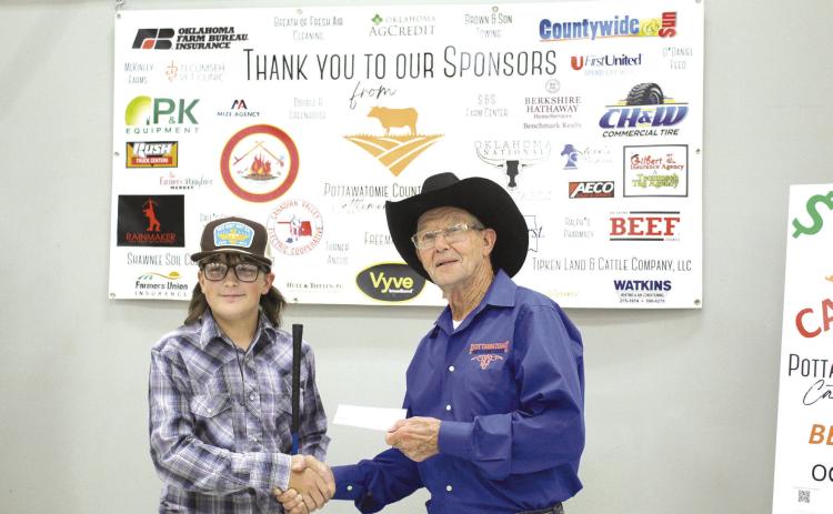 Sawyer Speers, a freshman in Tecumseh at the time, accepts a $900 check for sixth place from Pott. Co. Cattlemen’s Association President Bob Freeman in the 2022 Beef Quiz Bowl. Speers used his winnings to buy a Commercial bred heifer and will show the calf at the Pottawatomie County Junior Livestock Show, March 6. File photo.