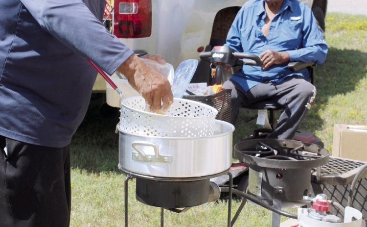 Frank Phillips batters and fries catfish outside the Brooksville Community Center, as his brother Leonard Phillips watches, during a fish fry fund-raiser on Aug. 23. Phillips caught about 150 pounds of catfish for the fund-raiser, which benefitted a new restroom at the Brooksville Cemetery. So far, the framework has been built for the restroom, and Brooksville Mayor Charles Carthen said, in addition to mens' and womens' restrooms, it will have a sitting area.