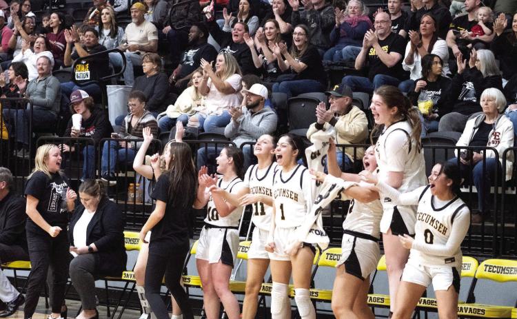 The Tecumseh Lady Savage starters cheer from the bench during the second half of the Class 4A District game with Crossings Christian on Feb. 17. They won the district championship, 79-26. Photo provided by Kenetta Lisenbee.