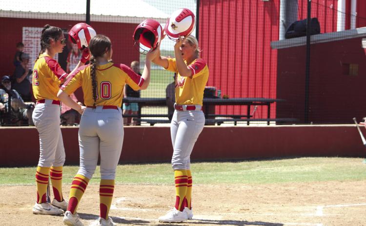 Dale’s Chayse Caram, far right, hits helmets with her teammates after hitting a home run in the fourth inning of the Dale Festival game with Silo on April 14. The Lady Pirates won that game, 12-7, and they won their two games on the previous day, as well. Dale beat Oktaha, 12-11, and Deer Creek, 13-1.