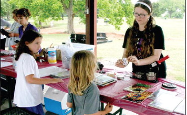Kaitlyn Love, long time helper of the Summer Reading Challenge, creates custom comic book buttons for kids at Slick Humphrey Park, hosted by the Tecumseh Public Library. Countywide &amp; Sun/Valerie Scott
