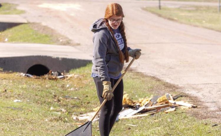An Oklahoma Baptist University student rakes debris after a tornado tore through the area April 19. Photo provided