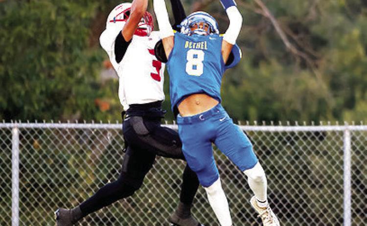 Bethel junior Garrison Reid (#8) and McLoud senior Sabir Perry grab for the ball during Bethel's first home game on Sept. 12. The Wildcats won, 58-32. Photo courtesy of Richelle Treece