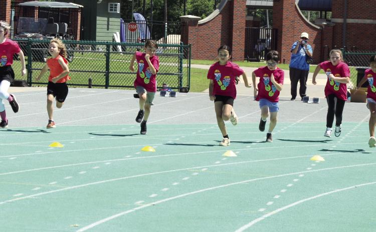 Students in first through sixth grade race during the Health Week Track Clinic, as former track star Charles Clark, far right, watches, at Oklahoma Baptist University on May 28. There were 48 students who participated in two sessions, said Macy Muirhead with Pottawatomie Go (POGO). Photos by Natasha Dunagan, Countywide & Sun