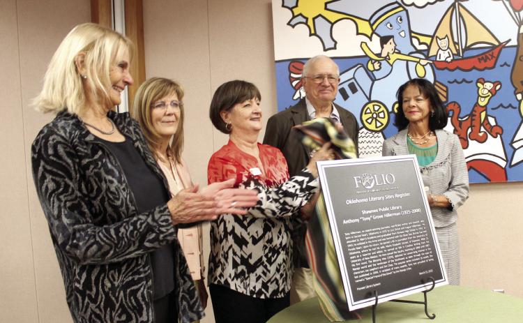 A new Oklahoma Literary Sites Register plaque for the late author Tony Hillerman is unveiled during a dedication ceremony at Shawnee Public Library on March 15 in celebration of the 100th anniversary of his birth year. Shown, from left, are Anne Hillerman, author and daughter of Hillerman; Lisa Wells, Pioneer Library Systems Director; Mary Sims, Shawnee library branch manager; Dr. Bill Hagen, Emeritus Professor of English at OBU; and, Angie Lewis, President of Friends of Libraries in Oklahoma.