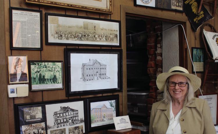 Tecumseh Historical Society member Arthenia Haney, dressed as Kate Barnard, rings a school bell amidst the display about Barnard and the elementary school named after her on April 11. Haney will be playing Barnard again for the Tecumseh Museum's 30th Anniversary Open House on April 19 from 10 am to 2 pm. Prints of the Tecumseh Centennial painting by Barbara Hertz will also be in a silent auction that day. Natasha Dunagan, Countywide & Sun