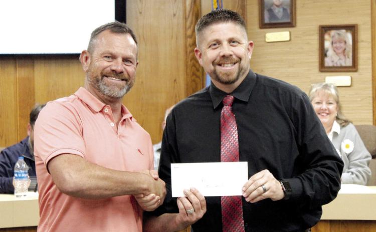 Community Renewal representative Brandon Dyer, left, presents a donation for $45,000 to Shawnee Public Schools Superintendent Dr. Aaron Espolt during the Dec. 4 Board of Education meeting. Dyer said part of the donation came from the band, Foreigner, when they played a concert in Shawnee. Countywide & Sun/Natasha Dunagan