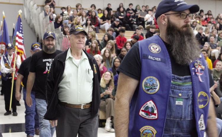 Navy veterans, from left, Philip Wolke, Charles Spillers and Becket Bircher walk in the Veterans Parade at the Tecumseh High School Veterans Day Assembly on Nov. 10. There were about 30 veterans who walked in the parade and were applauded as they lined up in front of the audience. There were also pictures of around 40 veterans, who were related to students and staff, shown in a slide show throughout the event. Countywide & Sun/Natasha Dunagan