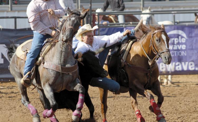 Dally Trussell of McLoud dismounts his horse during the steer wrestling event of the IFYR on July 11. Trussell competed in the National High School Finals Rodeo, July 13-19, as the Oklahoma High School Rodeo Association Champion Steer Wrestler. After three rides, his average was 18.69 seconds placing him second in the aggregate. Photos by Natasha Dunagan, Countywide & Sun