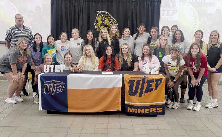 Tecumseh senior Serenity Jacoway, seated fourth from left, poses with the THS softball team and Tecumseh Head Fastpitch Coach Chad Trahan and Coach Kayla Rodriguez. Jacoway signed for softball with the University of Texas at El Paso on Nov. 8. Photo provided by Tracey Forrester.