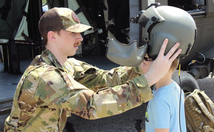 File photo In from of his Black Hawk helicopter, Sgt. Justin Donwerth places his helmet on Kaysen Meece, 4, of Texas, during Cops N' Kids on Aug. 23, 2025. The Sikorsky UH-60 Black Hawk will return this year, along with a few other helicopters, on Aug. 22.