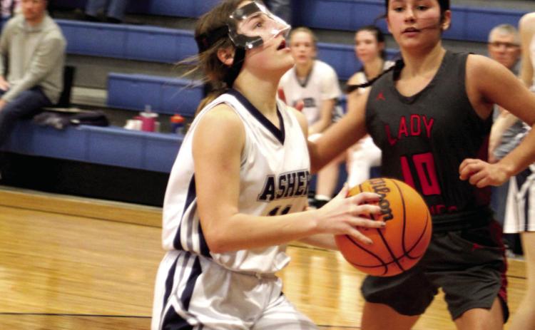 Asher’s Cadence Leba aims before making two points, as Macomb’s Aubree Akens guards, during the Asher home game on Jan. 28. The Asher Lady Indians won, 47-15. Countywide &amp; Sun/Natasha Dunagan