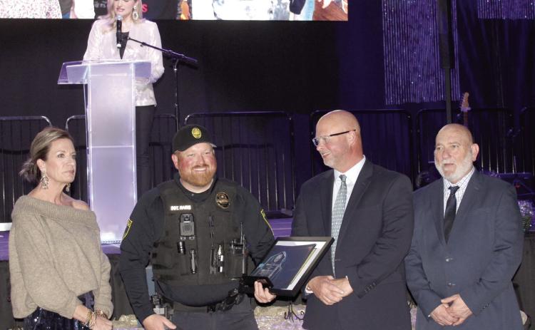 Sergeant Dennis Raines accepts the 2024 Officer of the Year Award from 2023 Officer of the Year Lt. Jason Crouch, third from left, during the 20th Annual “Celebration of Heroes” Shawnee Police Foundation Awards Banquet on Jan. 31. Raines responded to the scene of a stabbing where he applied compression gauze to two wounds until an ambulance arrived. Raines also received a Life Saving Award. Also shown are SPF Chair Melissa Stuteville, far left, and Deputy Chief John Goss. Abigail Ogle was the emcee.