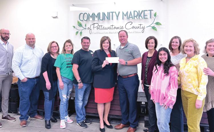 Kathy Laster, Ph. D. President &amp; CEO Avedis Foundation (center) presents a check to Daniel Matthews, Executive Director CMPC. Angi Mohr, Avedis Board Member &amp; President SSM Health St. Anthony Hospital Shawnee (pictured to the right of Matthews) is joined by Board and Staff from Community Market of Pottawatomie County and Staff from the Avedis Foundation. Photo provided