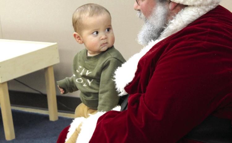 Seven-month-old Sutton Duarte, of OKC, looks worried as he sits on Santa’s lap at the Shawnee Pioneer Library on Nov. 17.