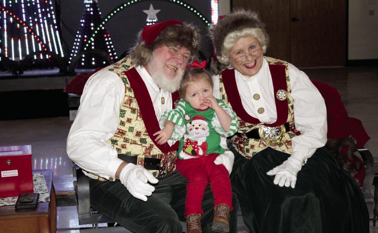 Sylar Coble, 2, of Meeker, poses with Santa and Mrs. Claus at the Paul and Ann Milburn Center, in Shawnee, on Dec. 3. Santa will return to the Pottawatomie County history museum on Dec. 10, 1-4 pm. There will be no admission fee that day. An indoor light show can also be seen before Dec. 24. Photos by Countywide &amp;Sun/ Natasha Dunagan