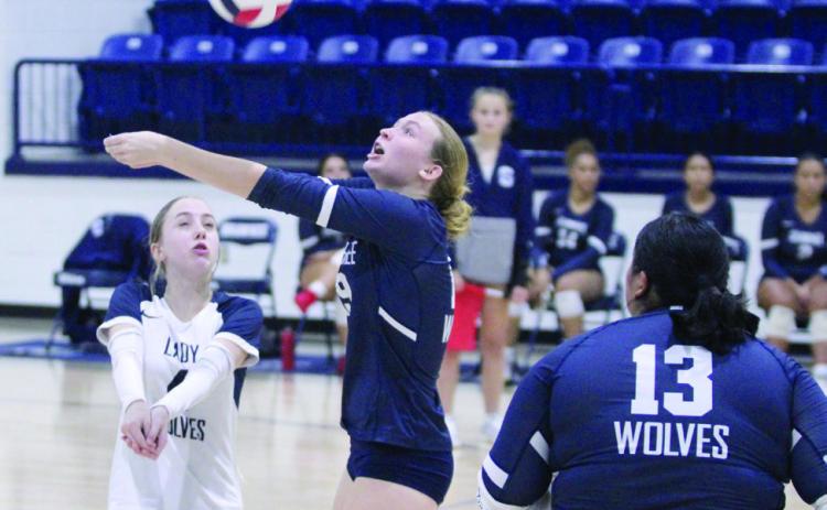 Shawnee’s Micah Teape makes a forearm pass, as Libero Kylee Moore backs her up at the home match with El Reno on Aug. 22. The Lady Wolves won, 3-0 (25-18, 25-12, 25-19).