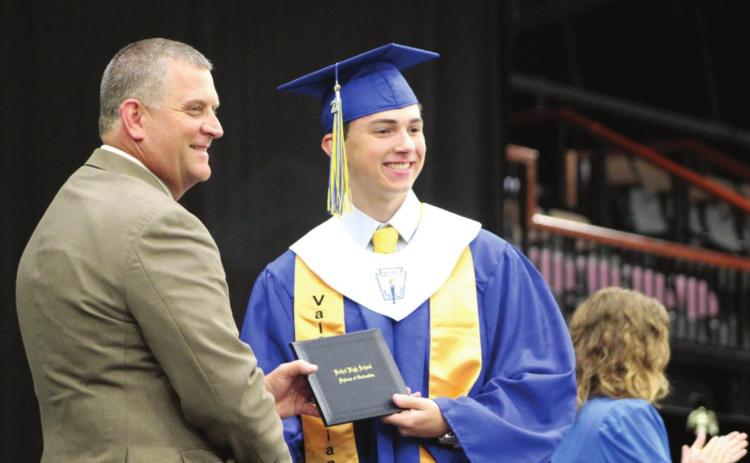 Bethel President of the Board of Education David Elmore presents Valedictorian Brady Gardner with his high school diploma on May 21. Bethel graduated 63 seniors this year.