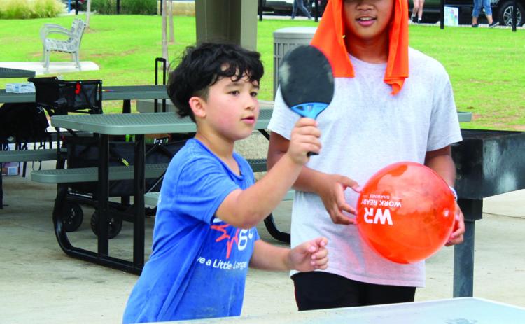 Troy Russ, 7, of Shawnee, plays ping pong, as Russell Tampus, 13, watches during the Health Week 'Fun Day at KidSpace Park' on the morning of May 29. Giant checkers, corn hole, pickleball, 40-yard dash, ninja course and the Roll and Stroll Walk were also available. A rain storm cut the activities short around 11 am. The event returned that evening from 5-8 pm. Natasha Dunagan, Countywide &amp; Sun