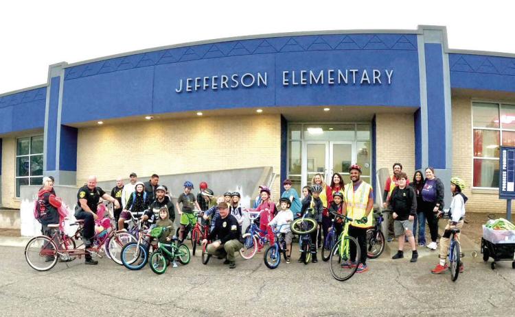 Pogo, Commissioner Odneal, and Jefferson students stand together outside the school after a successful ride to school on Bike to School Day. Photo provided