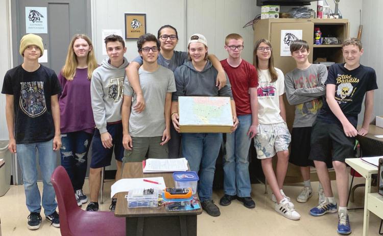 The students from Billy Crow’s Electronics and Amateur Radio Class at Tecumseh Public Schools gather around their map charting the journey of the International Space Station the day the school made radio contact with the station. Photo Provided